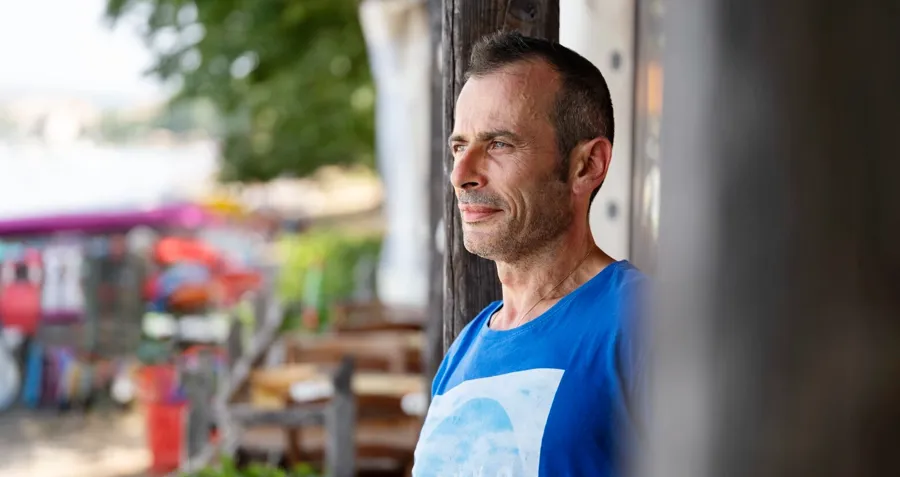 Portretfoto van Andrea buiten. Katheteriseren is een leerproces en na verloop van tijd leerde Andrea hoe hij onderweg een katheter moest inbrengen en ontwikkelde hij zijn eigen routine die hem paste. 