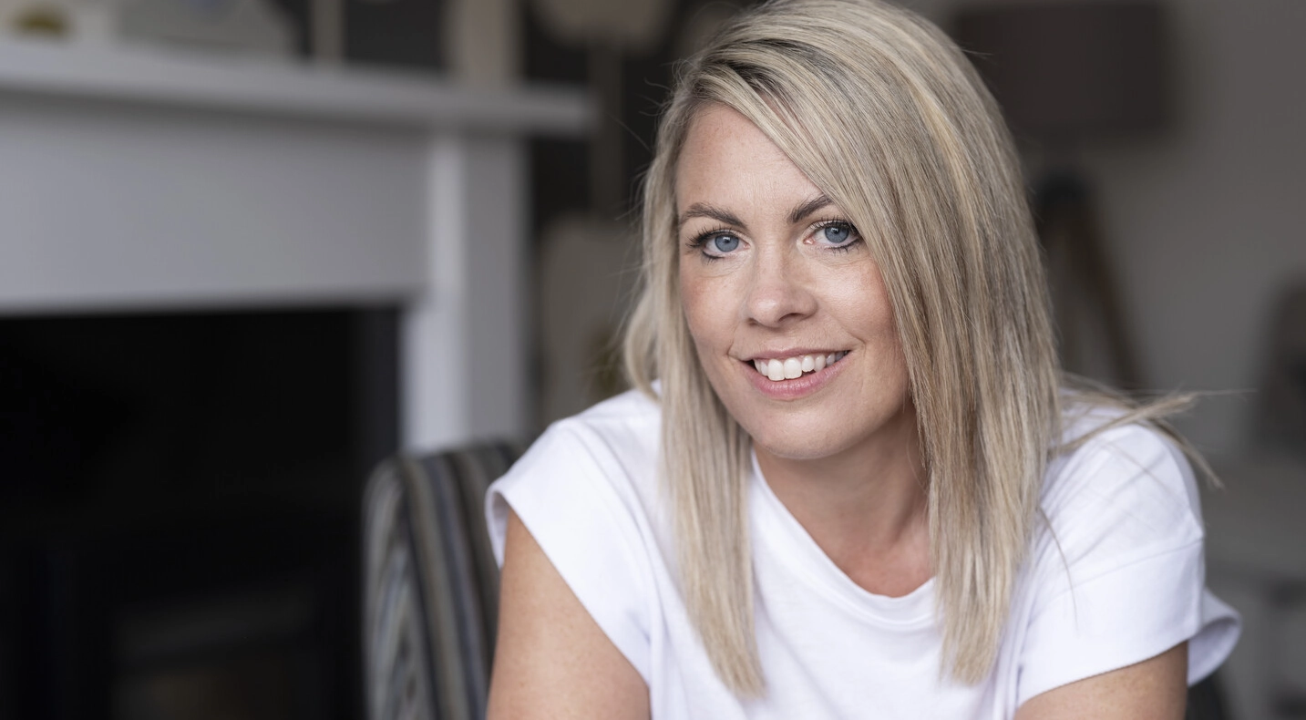 Laura, een gebruiker van SpeediCath® Compact Eve en Peristeen® Plus, zit in haar woonkamer. 