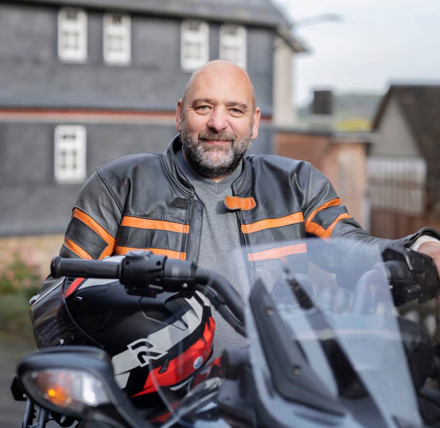 Portretfoto van Michael die op zijn motor zit. Michael leeft met MS en heeft blaasklachten. Hij merkte dat zijn blaas overactief was en dat hij vaker moest plassen dan andere mensen. 