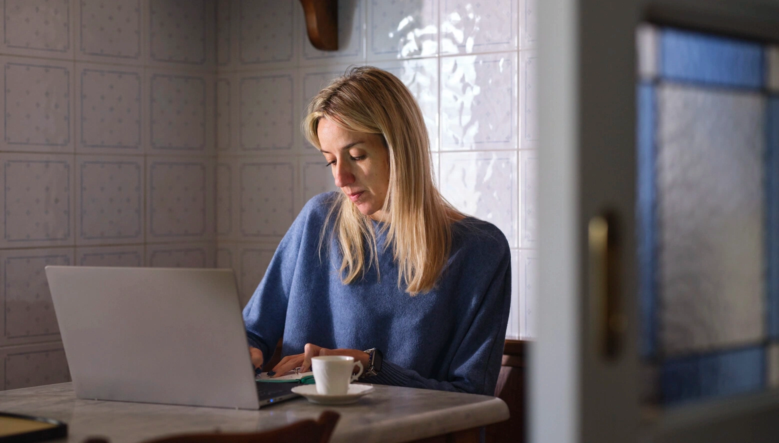 Afbeelding van Elisa, die leeft met MS, terwijl ze met haar laptop zit. MS kan de blaas en darmen beïnvloeden en kan leiden tot urineweginfecties en/of seksuele problemen. 